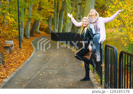 Two women walking in autumn park 120185176