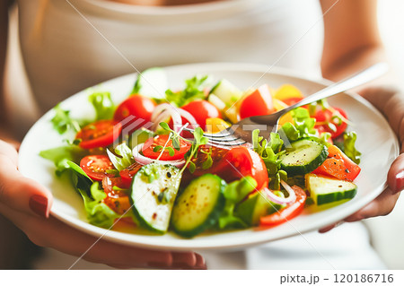 Woman eating salad with fork close-up, healthy eating concept 120186716