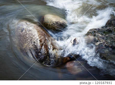 the water of the river flows around the stones the water of the river flows around the stones 120187931