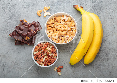 Cashews, peanuts, bananas and chocolate with hazelnuts representing magnesium rich food top view Cashews, peanuts, bananas and chocolate with hazelnuts representing magnesium rich food top view 120188824
