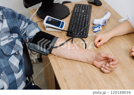 Patient blood pressure check in a clinic setting with digital monitor and medical devices Patient blood pressure check in a clinic setting with digital monitor and medical devices 120189039
