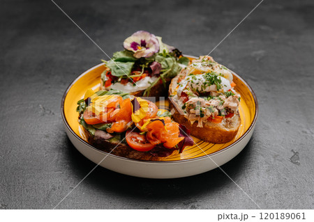 Assorted gourmet open-faced sandwiches with fresh toppings and edible flowers for a vibrant Assorted gourmet open-faced sandwiches with fresh toppings and edible flowers for a vibrant 120189061