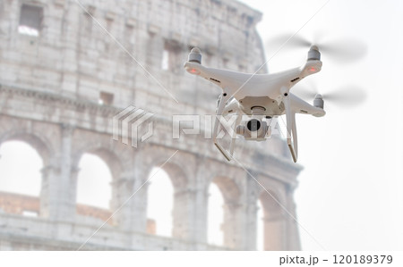Unmanned Aircraft System Quadcopter Drone UAV In The Air Near The Colosseum In Rome. Unmanned Aircraft System Quadcopter Drone UAV In The Air Near The Colosseum In Rome. 120189379