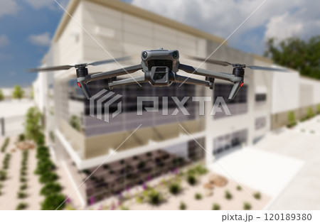 Unmanned Aircraft System Quadcopter Drone UAV In The Air Near Corporate Industrial Building 120189380