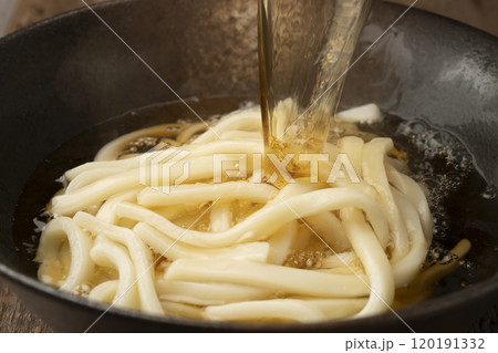 うどんに熱々の出汁を注ぐ 120191332