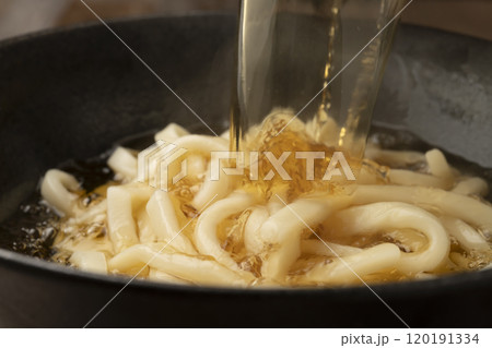 うどんに熱々の出汁を注ぐ 120191334
