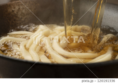 うどんに熱々の出汁を注ぐ 120191336