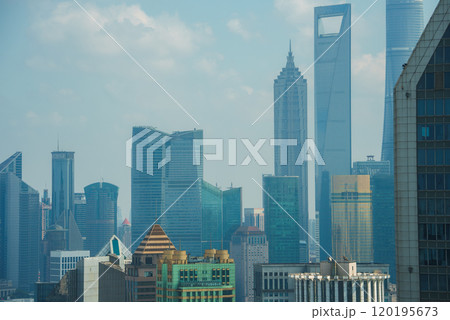 The image displays Shanghai's skyline, featuring the World Financial Center and Jin Mao Tower, amidst a mix of modern skyscrapers under a clear sky. 120195673