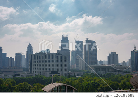 The image captures Shanghai's skyline, featuring Jin Mao Tower and Shanghai World Financial Center amidst modern skyscrapers and lush greenery. 120195699