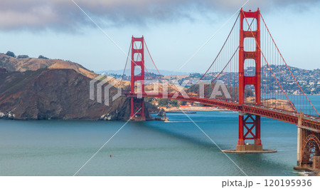 The Golden Gate Bridge's red orange towers and cables span the blue San Francisco Bay, with Marin County's hills visible in the background. The Golden Gate Bridge's red orange towers and cables span the blue San Francisco Bay, with Marin County's hills visible in the background. 120195936