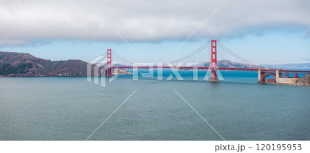 The Golden Gate Bridge in San Francisco, California, stands out in International Orange against blue water and sky, with Marin Headlands in the background. 120195953