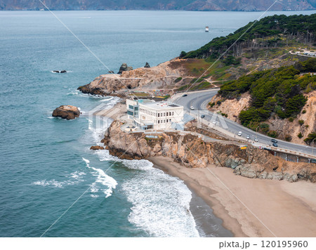 The historic Cliff House sits on a cliff in San Francisco, California, overlooking the Pacific Ocean with waves crashing against the rocky shore. 120195960