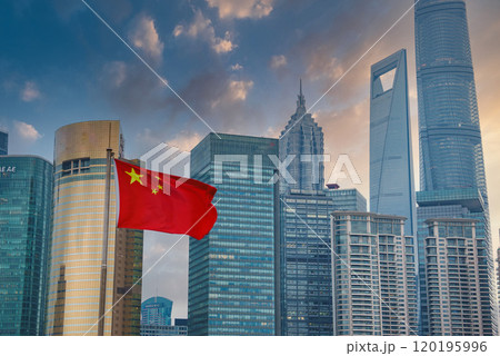 The image captures Shanghai's skyline with the Shanghai Tower and World Financial Center. A Chinese flag in the foreground adds a vibrant red contrast. The image captures Shanghai's skyline with the Shanghai Tower and World Financial Center. A Chinese flag in the foreground adds a vibrant red contrast. 120195996