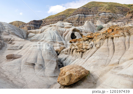 Canyon in badlands with eroded formations on the hills in summer. Canyon in badlands with eroded formations on the hills in summer. 120197439