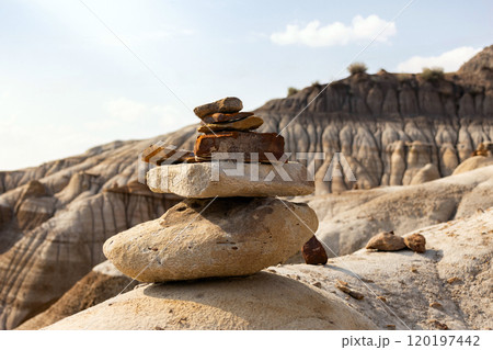 Stack of bright balancing rocks in badland canyon in summer. 120197442