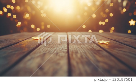 Golden stars on a wooden table with a magical bokeh background illuminated by sunset. 120197501