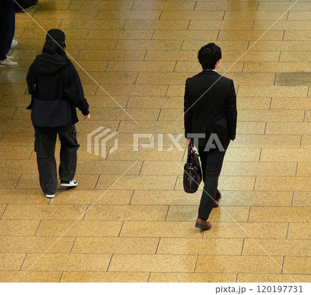 冬の名古屋駅の広場で歩く一人のサラリーマンの姿 冬の名古屋駅の広場で歩く一人のサラリーマンの姿 120197731