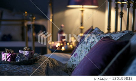 Bed and pillows in bedroom with Christmas tree and holiday decorations 120199832