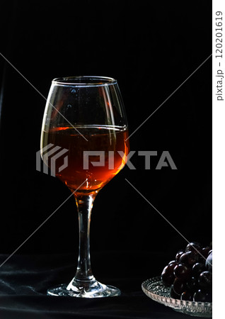 Wine glass with grapes on black background. Alcohol drink concept. Wine glass with grapes on black background. Alcohol drink concept. 120201619