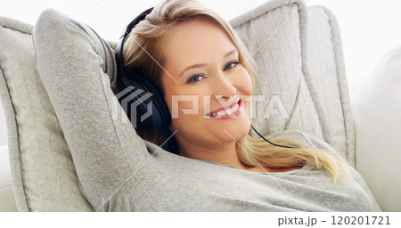 My fun time at home, just chilling listening to music. Shot of an attractive young woman listening to music with headphones at home. 120201721