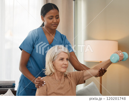 Living a better life with each lift. Shot of a senior woman using dumbbells during an exam with her doctor at home. 120201748