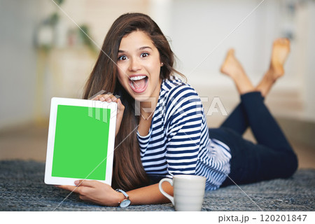 Can you believe this site. Portrait of an ecstatic young woman lying on the floor at home holding up a digital tablet with a chroma key screen. Can you believe this site. Portrait of an ecstatic young woman lying on the floor at home holding up a digital tablet with a chroma key screen. 120201847