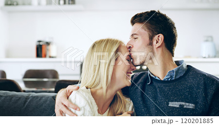 I love you so much. Cropped shot of a handsome young man kissing his girlfriend on the forehead while sitting on their sofa at home. I love you so much. Cropped shot of a handsome young man kissing his girlfriend on the forehead while sitting on their sofa at home. 120201885
