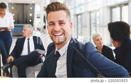 I am a part of the best project. Cropped portrait of a handsome young businessman sitting and smiling while his colleagues work behind him in the office. I am a part of the best project. Cropped portrait of a handsome young businessman sitting and smiling while his colleagues work behind him in the office. 120201925