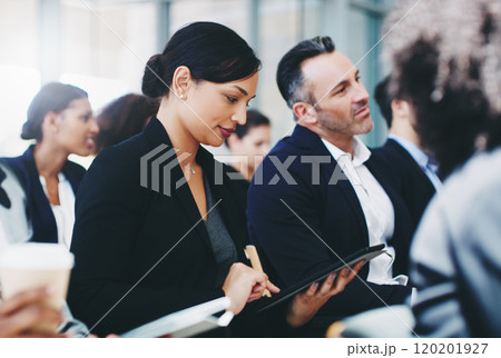 Taking as much info as she can from this presentation. Shot of a young businesswoman using a digital tablet while attending a conference. Taking as much info as she can from this presentation. Shot of a young businesswoman using a digital tablet while attending a conference. 120201927