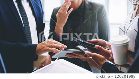 Technology helps our business move faster. Cropped shot of an unrecognizable group of businesspeople standing and using technology while in the office. 120201989