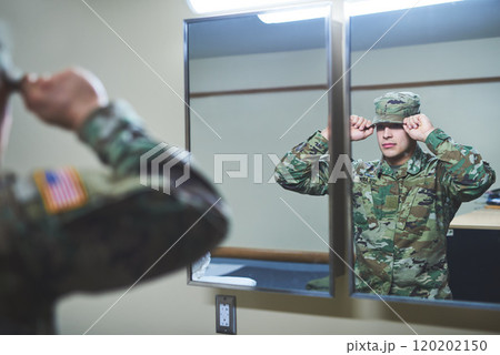 The battlefield is calling and I must go. Shot of a young soldier standing getting dressed in the dorms of a military academy. 120202150