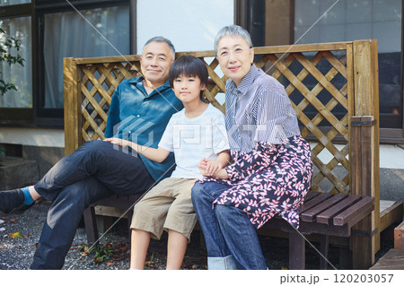 一軒家の外のベンチに座る孫と老夫婦 一軒家の外のベンチに座る孫と老夫婦 120203057