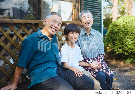 一軒家の外のベンチに座る孫と老夫婦 一軒家の外のベンチに座る孫と老夫婦 120203182