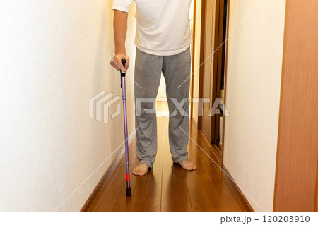 杖をついて廊下を歩く男性 120203910