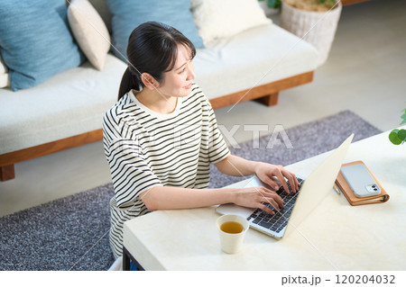 パソコン画面を見る若い女性　リビング　ワンルーム 120204032