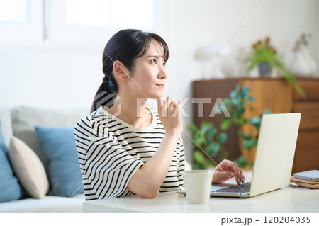 パソコン画面を見る若い女性 リビング ワンルーム パソコン画面を見る若い女性 リビング ワンルーム 120204035