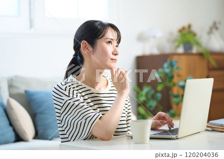 パソコン画面を見る若い女性　リビング　ワンルーム 120204036