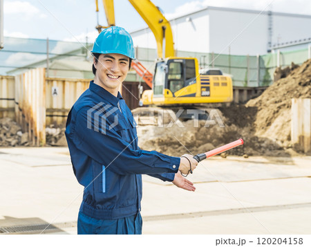 工事現場前で交通誘導する作業員 120204158