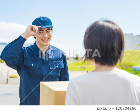 街で荷物を届ける男性配達員 街で荷物を届ける男性配達員 120204160