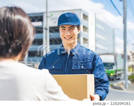 街で荷物を届ける男性配達員 街で荷物を届ける男性配達員 120204161