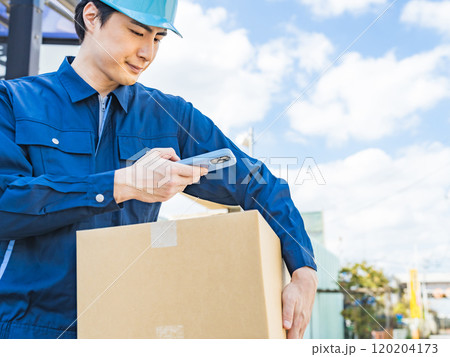荷物のラベルをスマホでスキャンする作業員 120204173