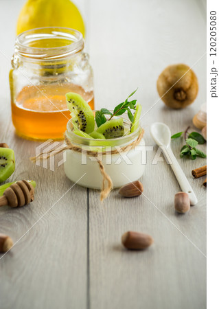 Homemade yogurt in a glass jar with honey, kiwi, nuts. Homemade yogurt in a glass jar with honey, kiwi, nuts. 120205080