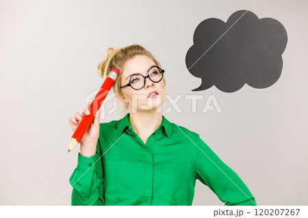 Woman holding big oversized pencil thinking 120207267