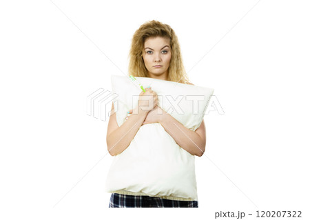 Sleepy woman hugging white pillow 120207322
