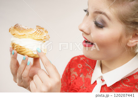 Funny woman holds cream puff cake 120207441