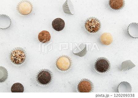 Typical Brazilian sweet brigadeiro. Assorted flavors of candies in a line on a blue background 120209338