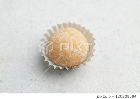 Typical Brazilian sweet brigadeiro. One coconut candy on a white background Typical Brazilian sweet brigadeiro. One coconut candy on a white background 120209394