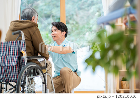 老人ホームの利用者と会話する男性介護士 120210010