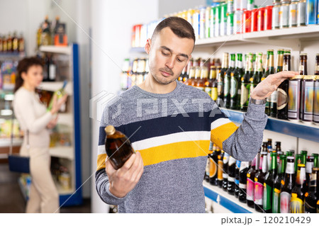In Russian goods store, man choose bottle of beer In Russian goods store, man choose bottle of beer 120210429