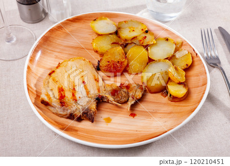 Grilled tasty pork meat with boiled potatoes served on table 120210451